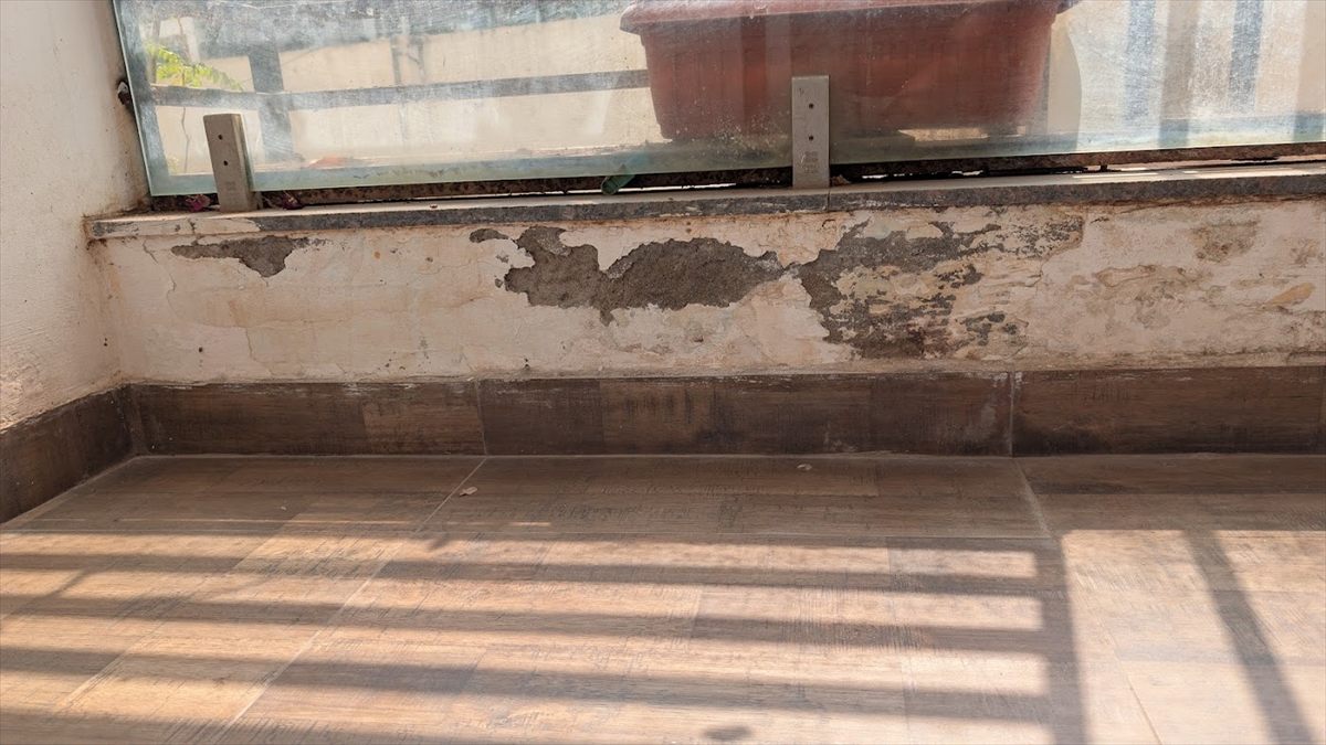 Damaged damp window-sill wall before treatment
