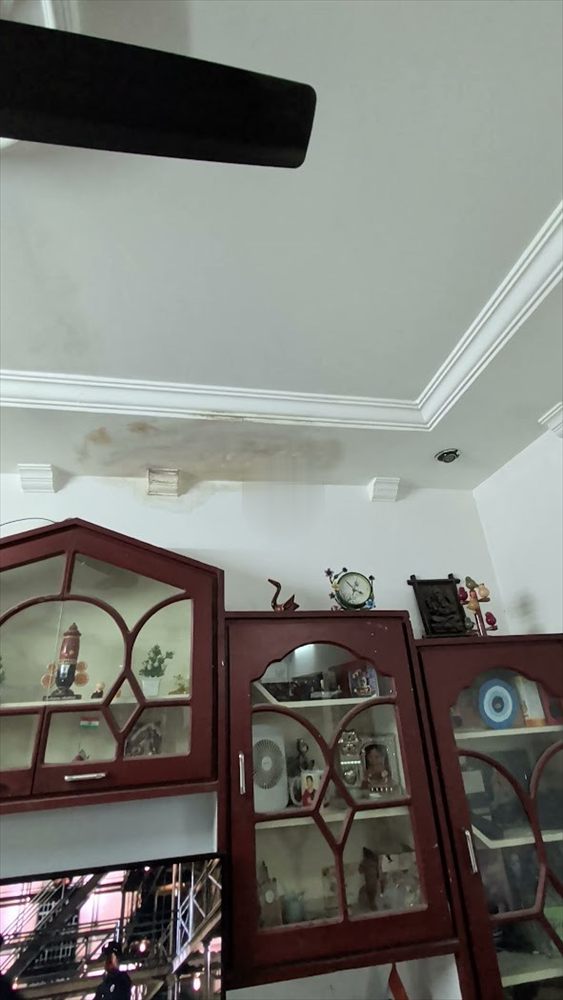 Seepage stain spreading across a living room ceiling