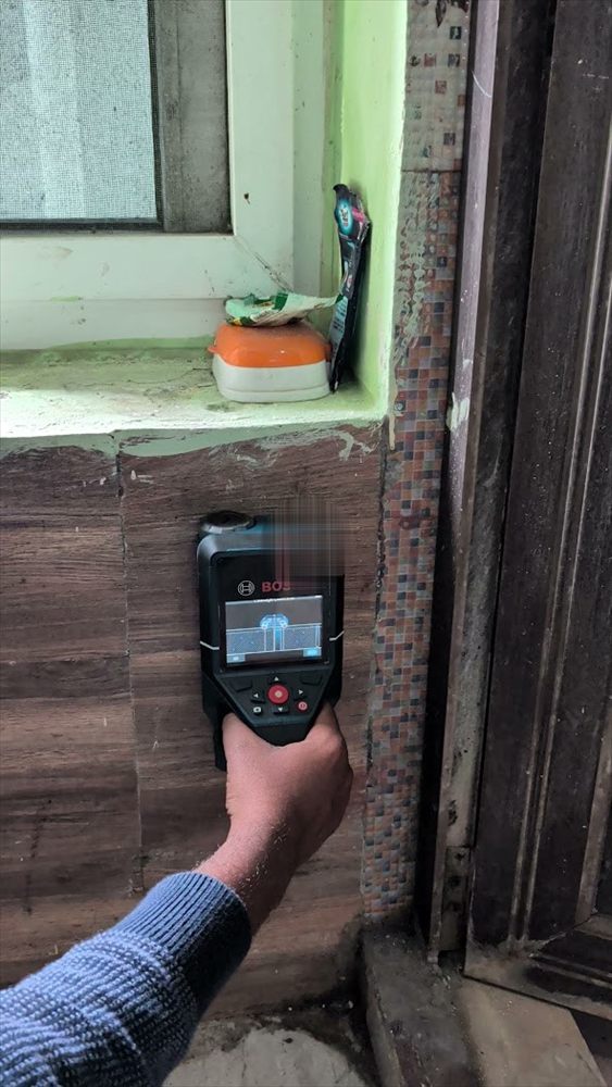 Engineer scanning a window sill for seepage